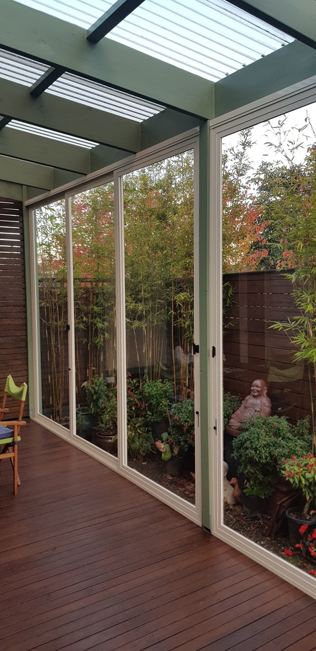 White framed clear PVC weather screens enclosing a timber veranda