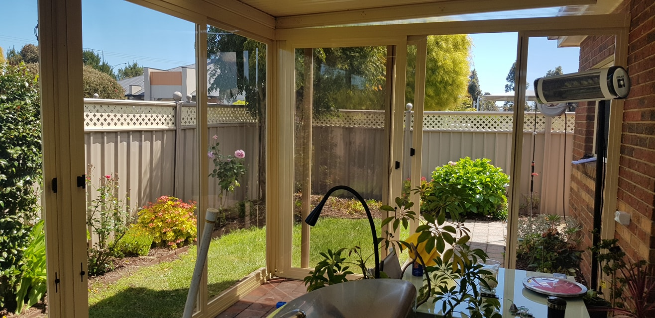 Cream framed weather screens creating a bright garden room