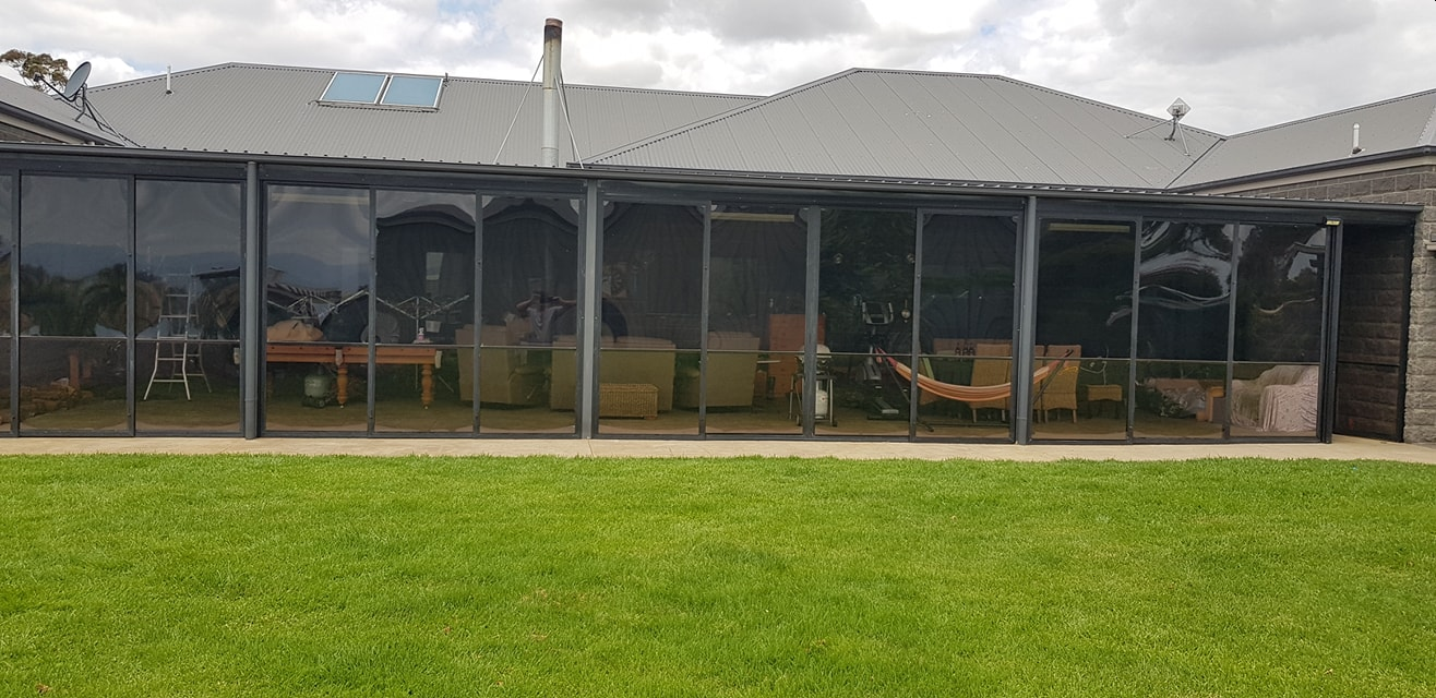 Wide charcoal weather screen installation across an alfresco area